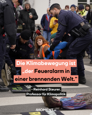 Klimaaktivist:innen sitzen auf der Straße. Polizist:innen versuchen einen von ihnen wegzutragen. 