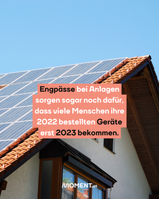 Auf dem Foto ist ein Haus mit Sonnenpanelen zu sehen. Text: Engpässe bei Anlagen sorgen sogar noch dafür, dass viele Menschen ihre 2022 bestellten Geräte erst 2023 bekommen.