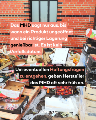 Vor einem Gebäude aus Backsteinen liegen viele Obstkisten voller Lebensmittel auf einem Haufen.