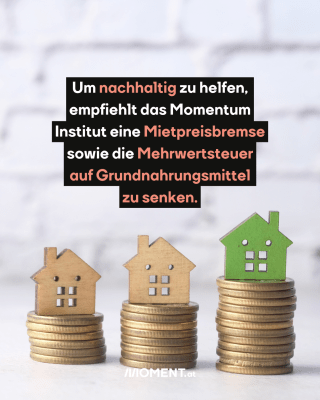 Auf drei Münzen-Stapel stehen kleine Haus-Figuren aus Holz.