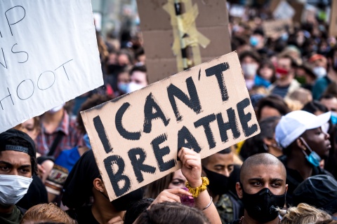 Man sieht ein Schild mit "I can't breathe"