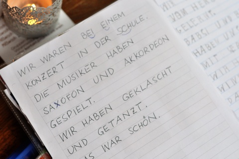 Foto von einer Seite aus Soufienes Schulheft. Geschrieben in Großbuchstaben: „Wir waren bei einem Konzert in der Schule. Die Musiker haben Saxofon und Akkordeon gespielt. Wir haben geklatscht und getanzt. Das war schön“