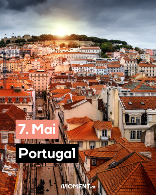 Ein Bild von Portugal von oben. Viele Häuser mit roten Dächern sind zu sehen. Im Hintergrund geht hinter einem Hügel die Sonne langsam unter.