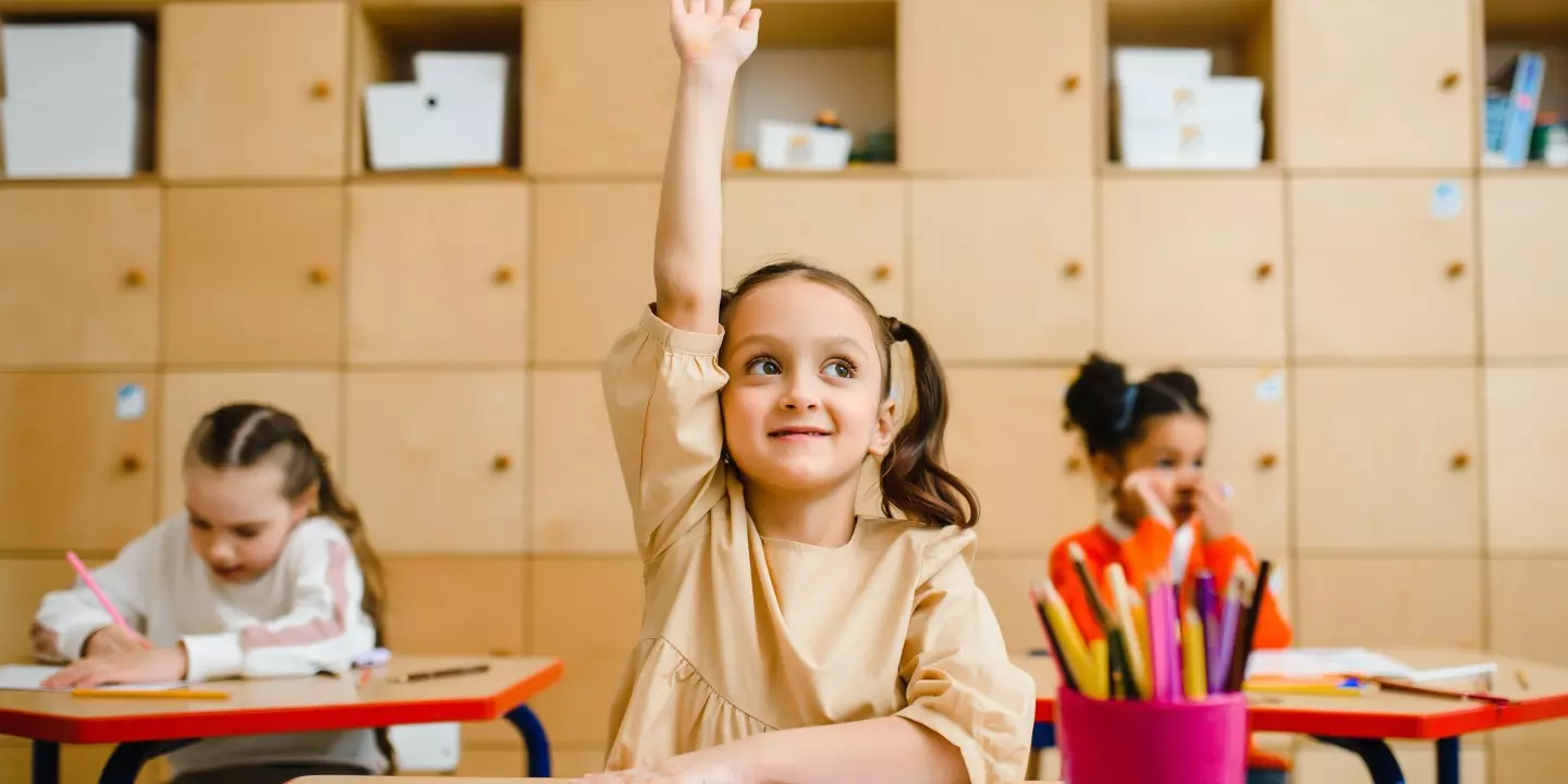 Bildung in Österreich: Was brauchen Kinder und Lehrer:innen? - Bild: Ein Kind zeigt im Unterricht grinsend auf