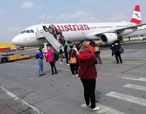 Personenbetreuerinnen besteigen ein Flugzeug, das zum Abflug von Timisoara bereit steht.