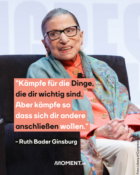 Ruth Bader Ginsburg, eine ältere Dame mit Brille, sitzt in einem schwarzen Sessel. Offenbar auf einer Bühne.
