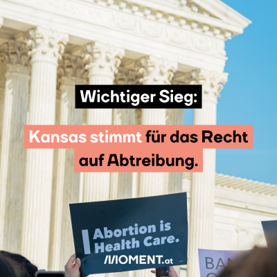 Eine Person hält ein blaues Schild hoch. Auf dem steht “Abortion is Health Care.” Im Hintergrund sieht man verschwommen einen Teil des Gebäudes, in dem sich der US Supreme-Court befindet. “Wichtiger Sieg: Kansas stimmt für das Recht auf Abtreibung”