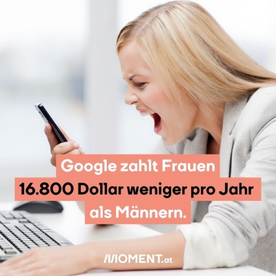 Eine blonde Frau mit grauem Blazer sitzt an einem Tisch. Vor ihr liegt ein Keyboard und eine Maus. Sie hat ein Handy in der Hand und schreit wütend hinein.