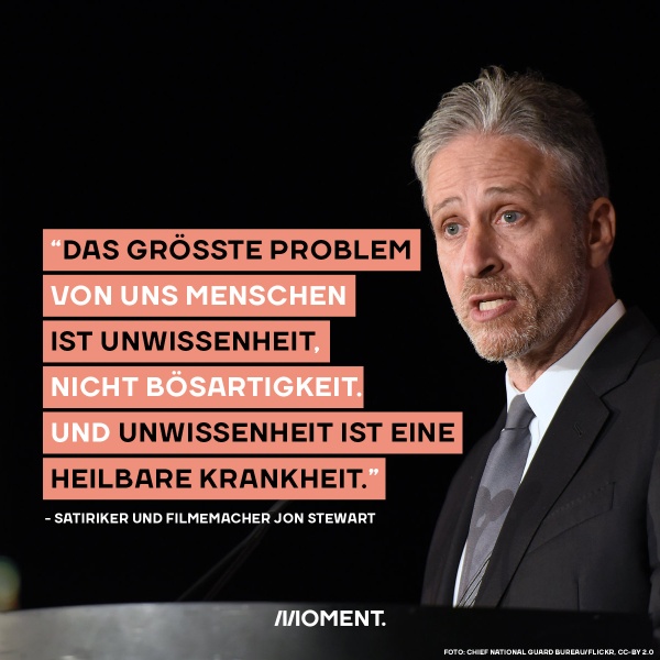 Jon Stewart hält Unwissenheit für unser größtes Problem. Jon Stewart trägt einen Anzug und spricht ins Publikum. Zitat: Das größte Problem von uns Menschen ist Unwissenheit, nicht Bösartigkeit. Und Unwissenheit ist einen heilbare Krankheit."