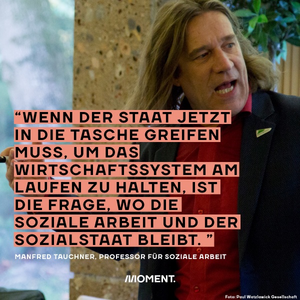 Manfred Tauchner erklärt etwas und blickt dabei ins Publikum. Zitat des Professors für soziale Arbeit: "Wenn der Staat jetzt in die Tasche greifen muss, um das Wirtschaftssystem am Laufen zu halten, ist die Frage, wo die soziale Arbeit und der Sozialstaat bleibt."