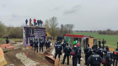 Bild zeigt Gebäude auf besetzter Baustelle, davor Polizei