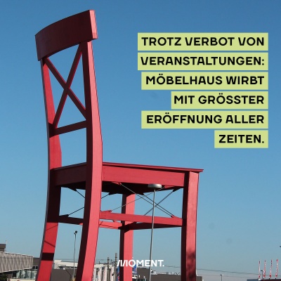 Foto zeigt einen überdimensionierten roten Stuhl, das Markenzeichen der Möbelkette XXXLutz. Text: Lutz plante Eröffnung trotz Corona.