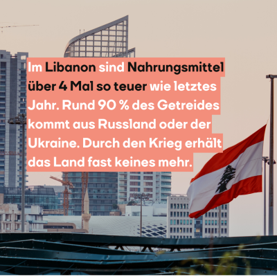 Die Flagge des Libanon hängt auf Halbmast, dahinter sieht man ein Hochaus stehen.