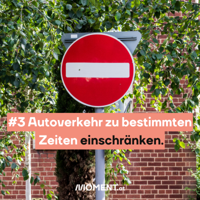 Ein Einfahrt verboten-Schild steht vor einer bewachsenen Ziegelwand. “Autoverkehr zu bestimmten Zeiten einschränken”