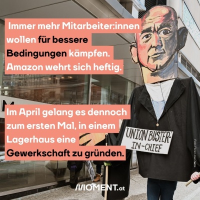 Eine große Puppe aus Pappe wird von 2 Männern gehalten. Sie soll den ehemaligen Amazon-CEO Jeff Bezos darstellen. Auf ihr ist der Schriftzug “Union Buster-in-Chief” angebracht.