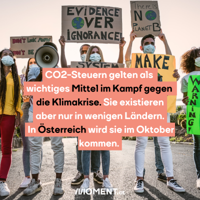 Eine Ansammlung von Personen. Sie tragen Masken und halten Schilder mit Slogans wie "Evidence Over Ignorance" in den Händen. "Eine <span class=