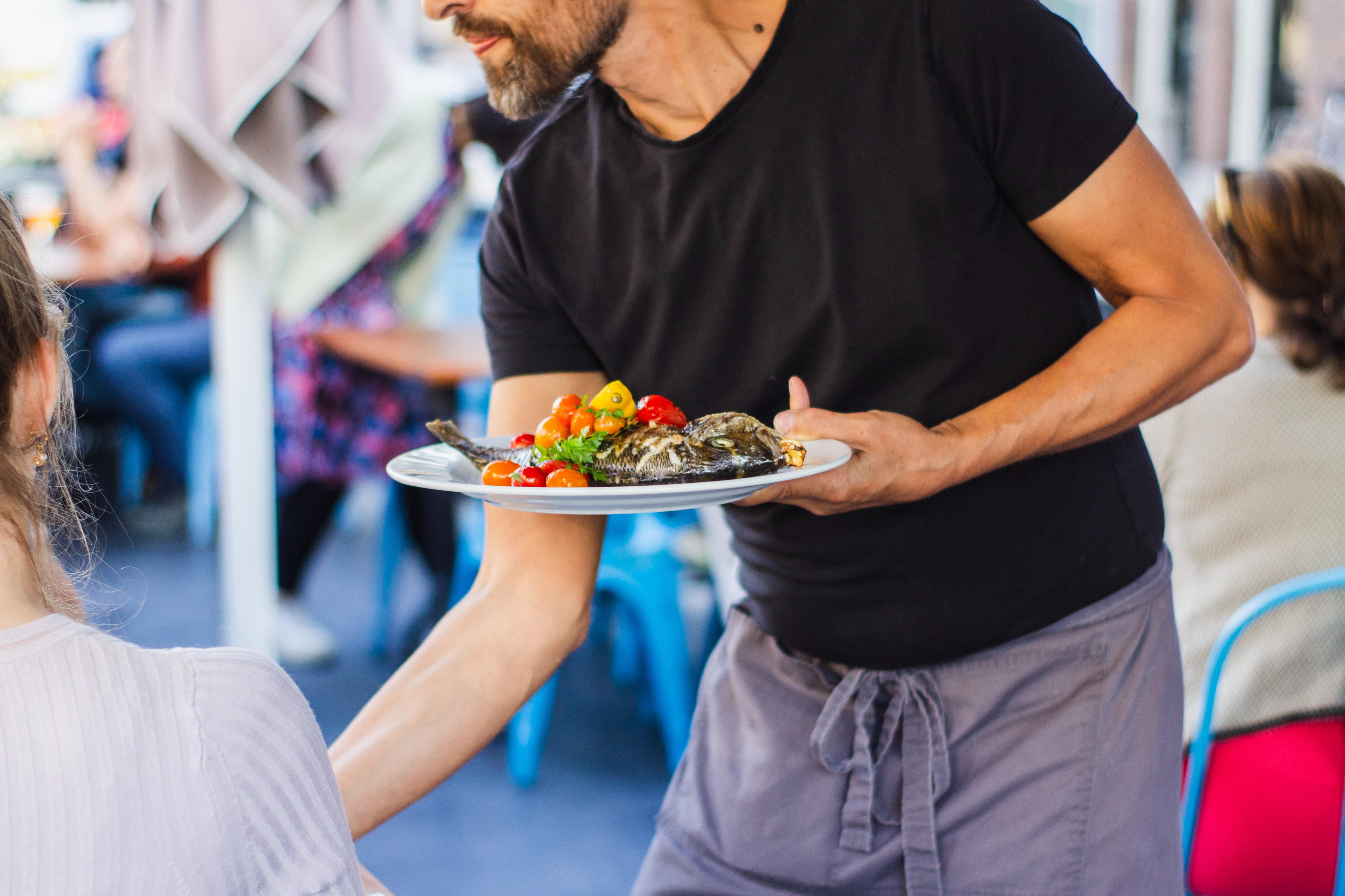 Kellner serviert einen Salat.