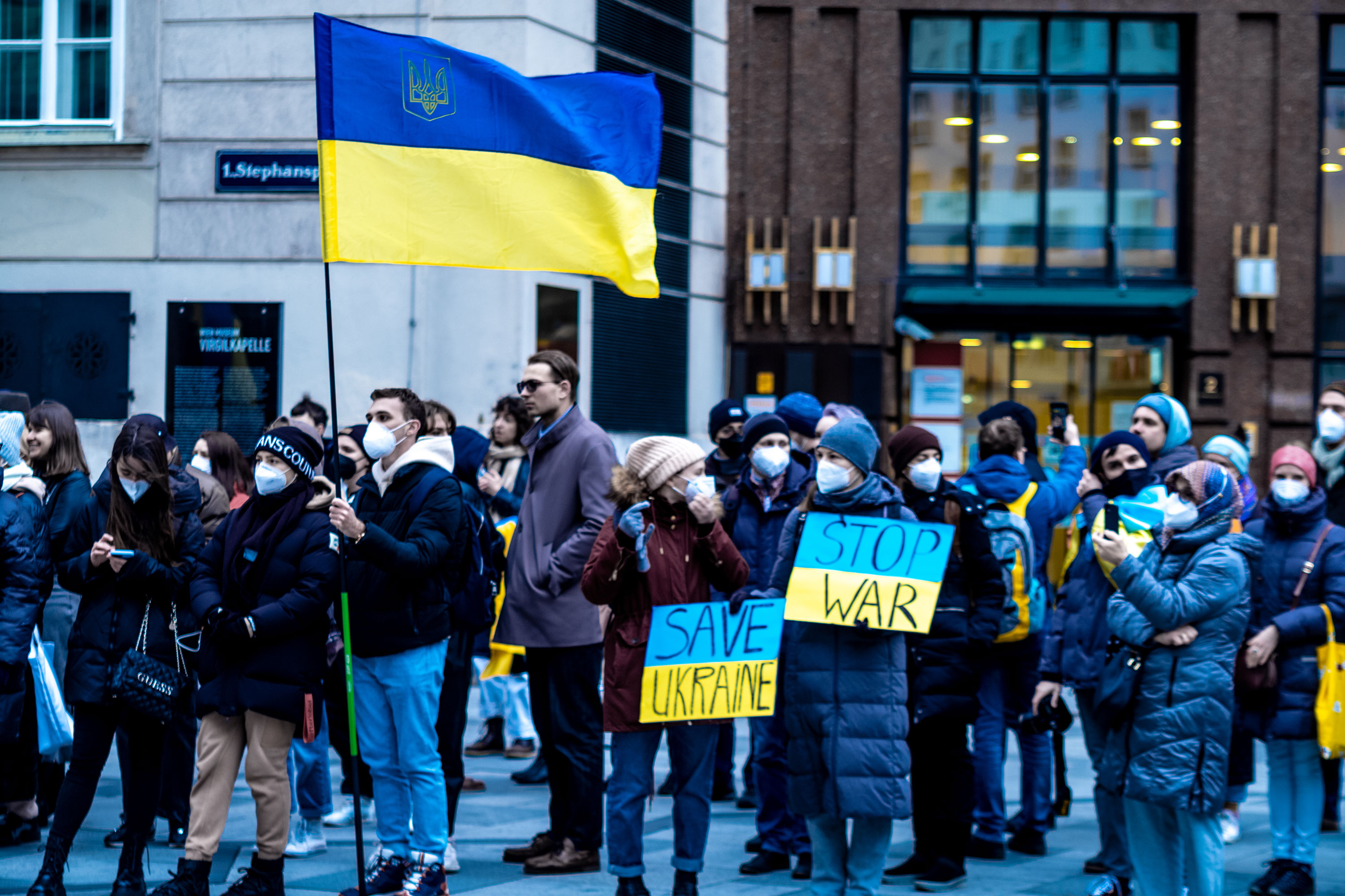 Krieg in der Ukraine: Wie kannst du in Österreich helfen? Zu sehen sind Menschen am Stephansplatz, die gegen den Krieg demonstrieren. Sie tragen Schilder mit der Aufschrift: "Stop War, Save Ukraine"