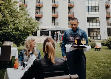 Kellner bedient Gäste vor dem Parkhotel Brunauer