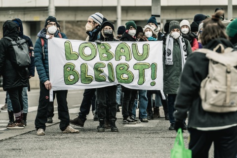 Protestcamp-Räumung: Demonstrierende mit Banner "Lobau bleibt!"