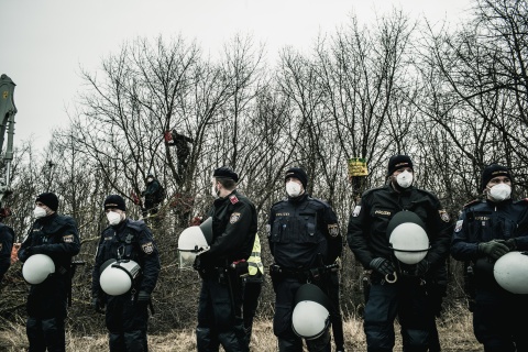 Protestcamp-Räumung: Polizist:innen vor Demonstrierenden in Bäumen