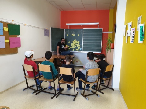 Schüler einer NMS sitzen im Sesselkreis und erstellen gemeinsam mit dem Gesundheitstrainer einen Stressplan.