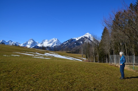 Christina Zauner auf einer riesigen Wiese am Waldrand, im Hintergrund Berge