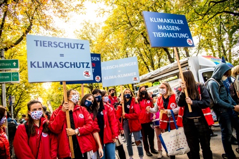 Rot gekleidete Menschen mit Schildern zu Klimaschutz und Tierschutz beim Klimastreik 2021 in Wien