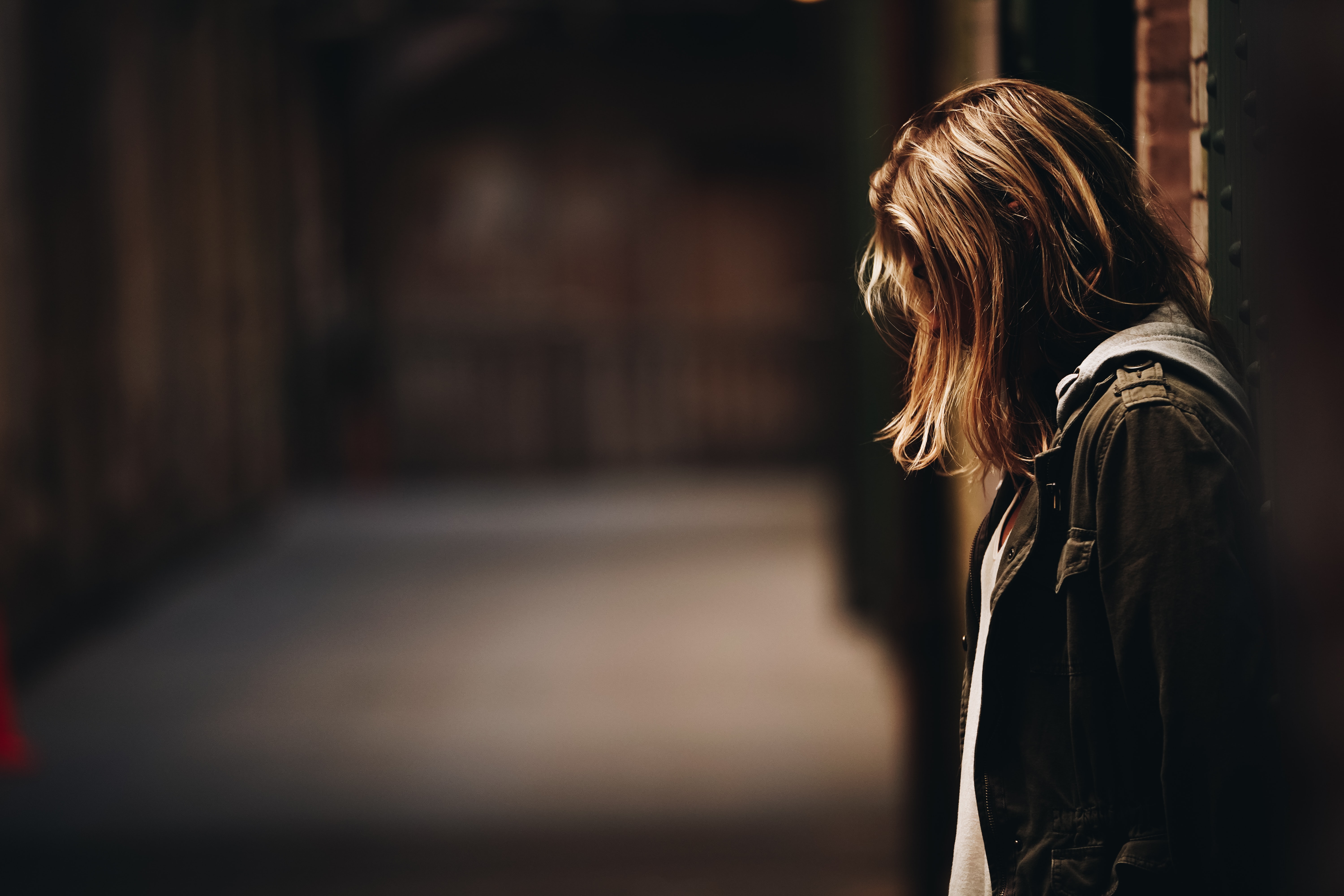 Eine Person steht mit gesenktem Kopf, man sieht nur schulterlange blonde Haare, kein Gesicht. Im Text geht es um Depressionen bei Jugendlichen.