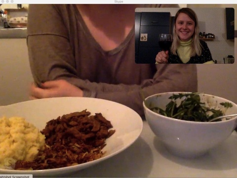 Skype-Screenshot: Essen und eine Frau, die mit Rotwein prostet.