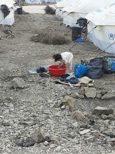 Ein Mädchen wäscht sich im Flüchtlingslager Kara Tepe auf Lesbos in einem Kübel