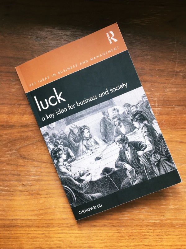 Das Cover von Luck: a key idea for business and society von Chengwei Liu. Auf dem Cover ist Tisch zu sehen an dem Männer und Frauen einem Glückspiel nachgehen.