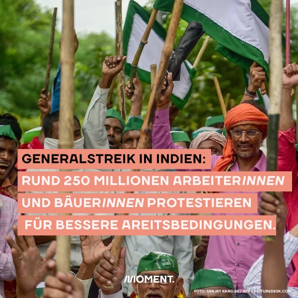 Foto zeigt Protestierende mit Fahnen und erhobenen Armen. Text: Generalstreik in Indien: Rund 200 Millionen ArbeiterInnen und BäuerInnen protestieren für bessere Arbeitsbedingungen.