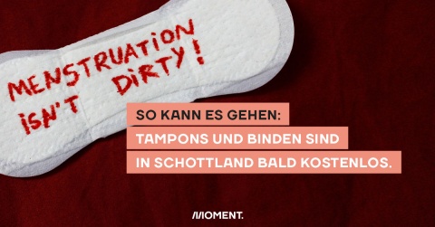 Foto zeigt eine Binde auf der in roter Schrift "Menstruation isn't dirty" zu lesen ist. Text: So kann es gehen: Tampons und Binden sind in Schottland bald kostenlos.