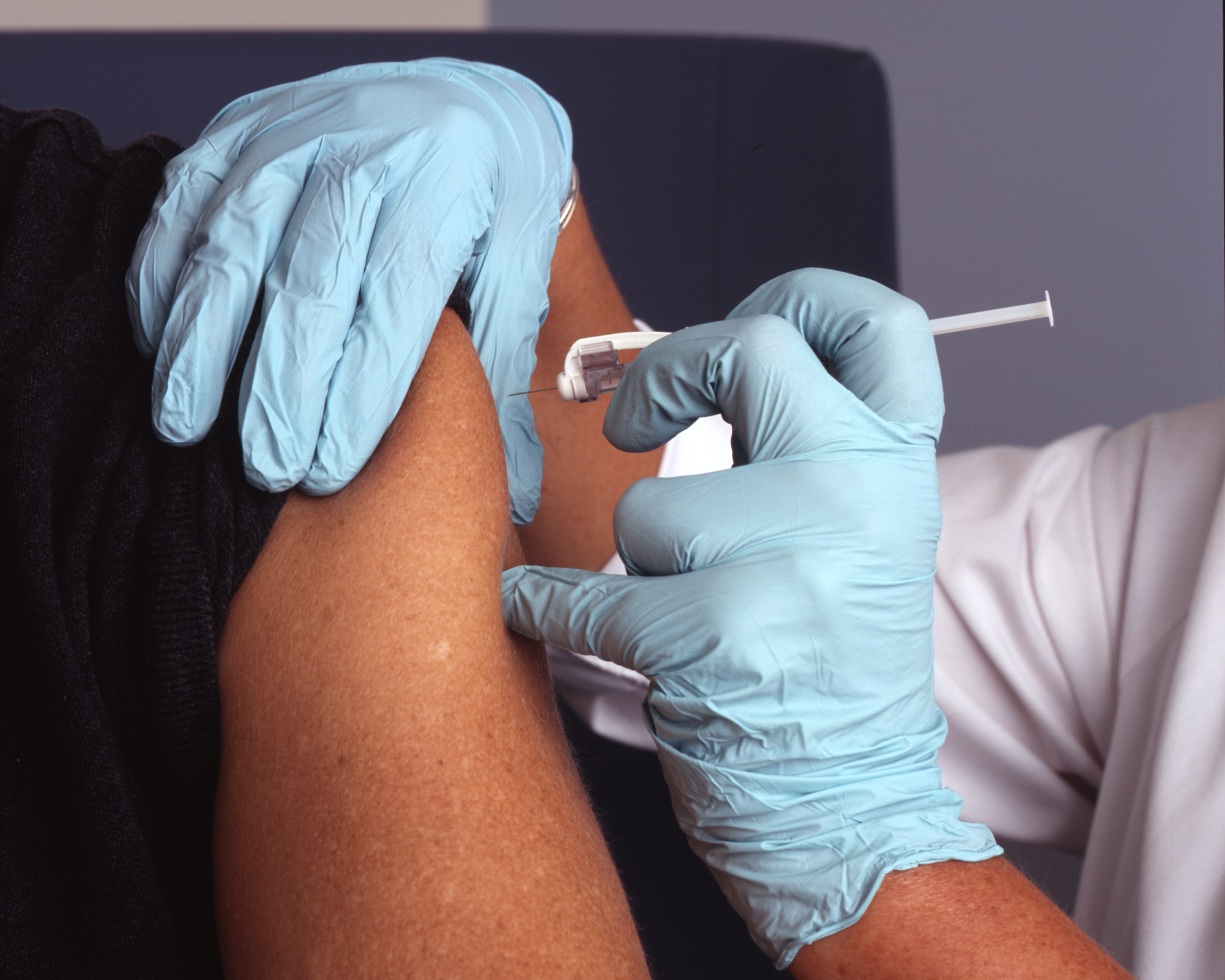 Eine Impfung wird in einen Oberarm injiziert.