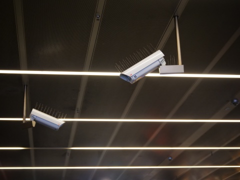 Zwei weiße, klobige Überwachungskameras hängen von der Decke