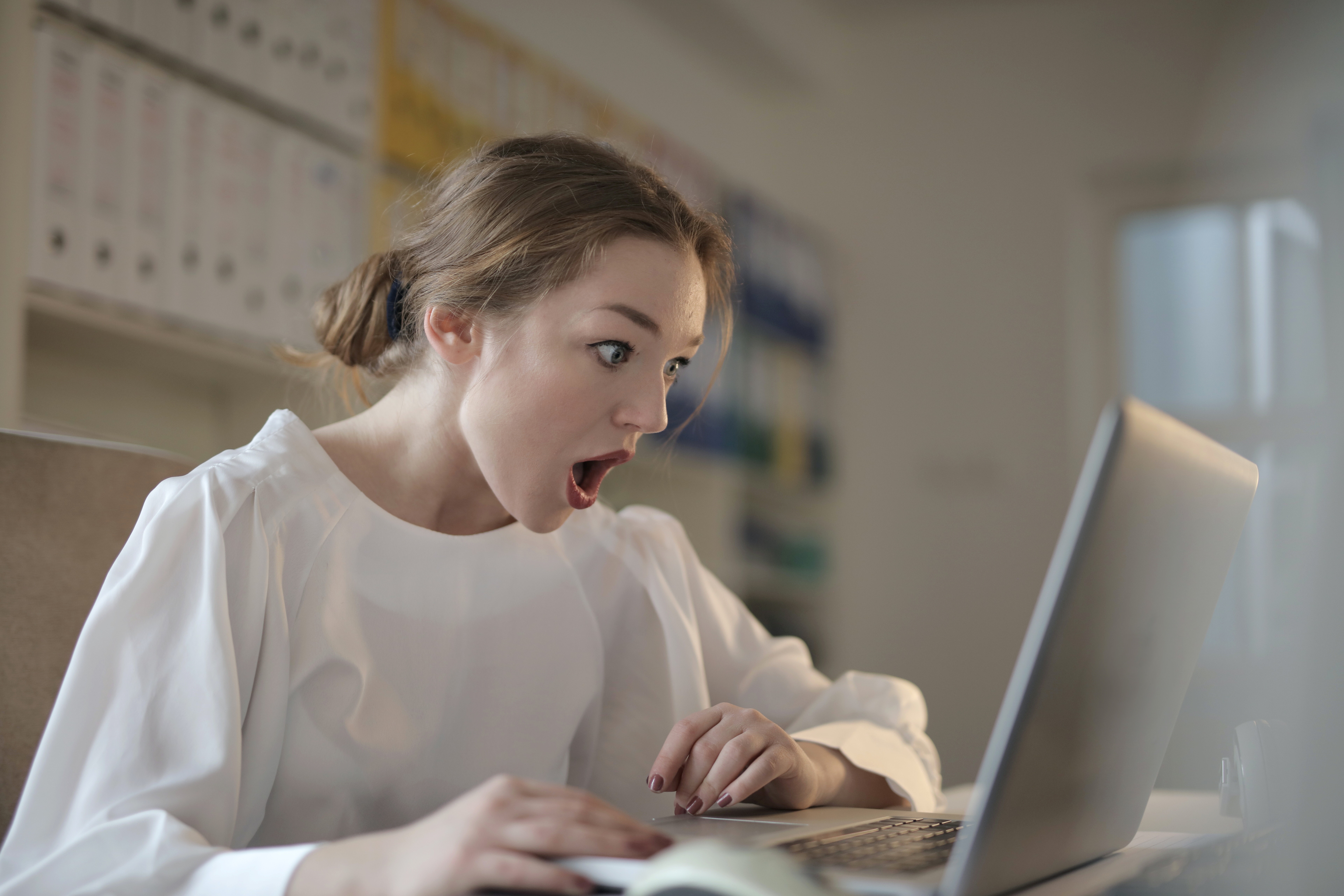 Frau schaut fassungslos auf Computerbildschirm