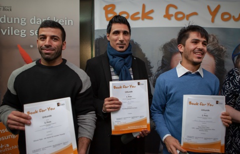 Drei Gewinner des Ute Bock Preises für Asylwerber zeigen stolz ihre Urkunden in die Kamera.