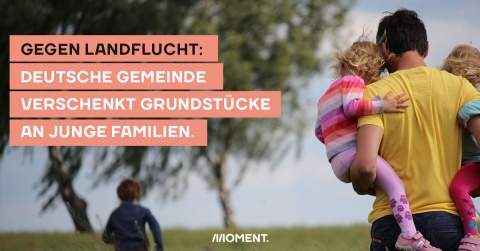 Foto zeigt zwei Kinder und eine erwachsene Person. Eines der Kinder läuft auf zwei Bäume zu und das zweite wird vom Erwachsenen auf dem Arm getragen. Text: Gegen Landflucht: Gemeinde verschenkt Grundstücke an junge Familien.