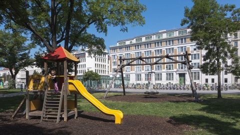 Foto zeigt den Kinderspielplatz im Bruno Kreisky Park, im Hintergrund ist derBerufsschulkomplex Mollardgasse zu sehen.