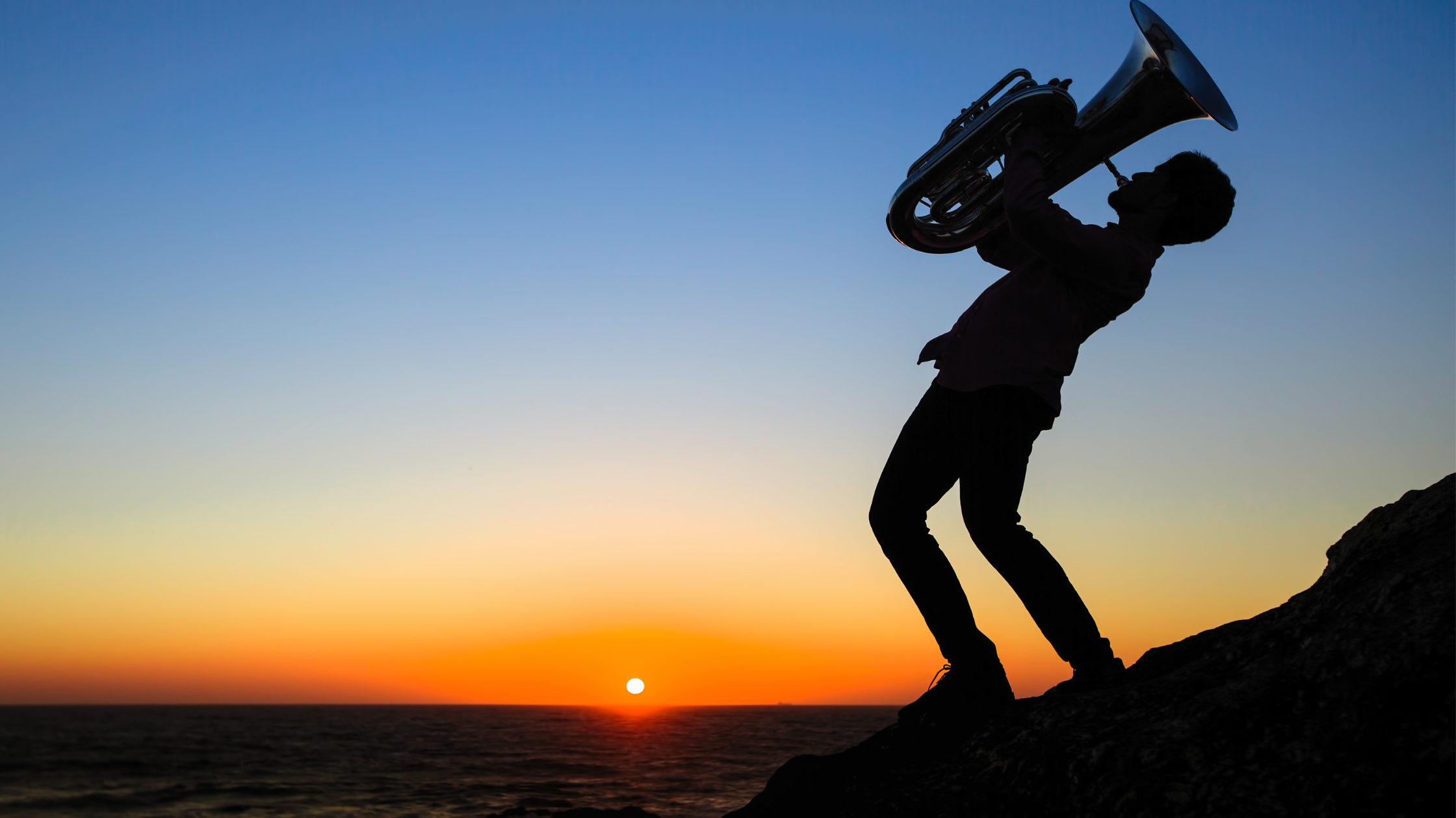 Die Silhouette eines Mannes, der ein Blasinstrument spielt.