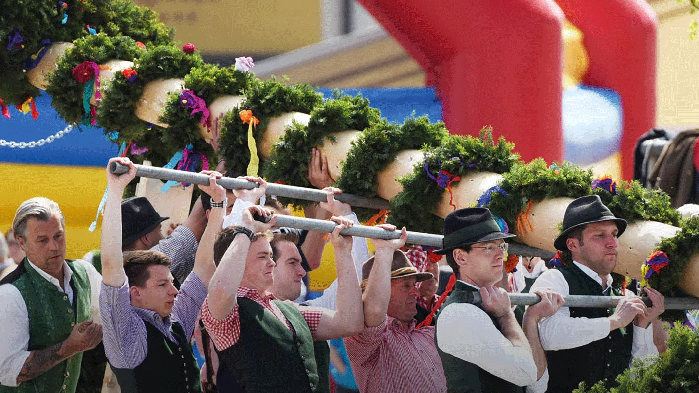 Ein Bild der viel krtisierten ÖVP-Leitkultur-Kampagne: Menschen in Trachtengewand stellen einen Maibaum auf. Hier weggeschnitten ist aus Platzgründen der umstrittene Slogan "Tradition statt Multikulti. Das ist für die Leit-Kultur."