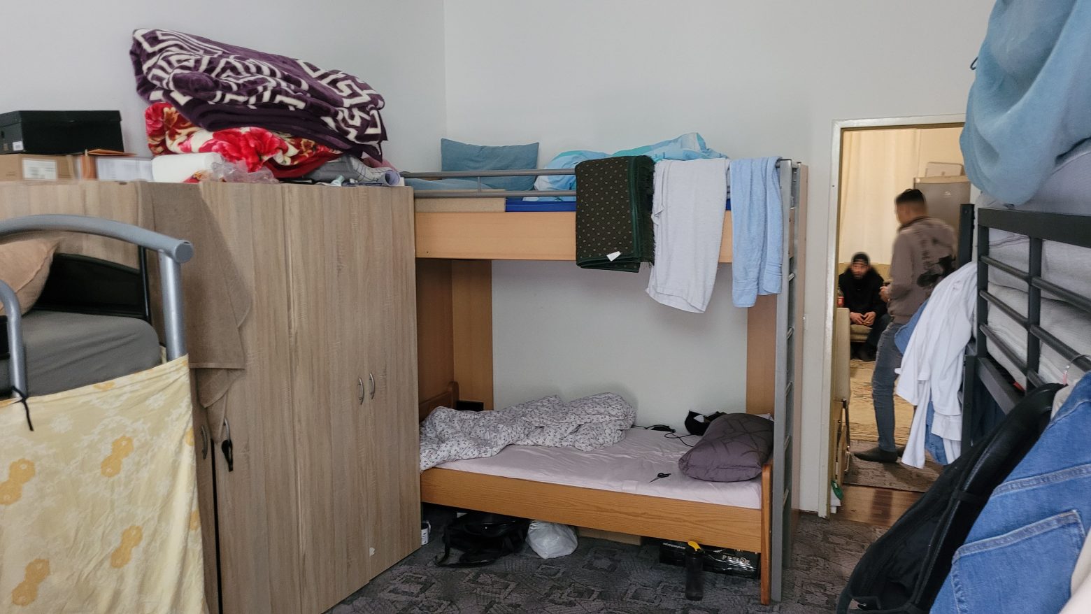 Ein kleines Zimmer voller Stockbetten in denen die Geflüchteten Menschen als Groß-WG wohnen