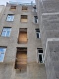 Foto zeigt den Hof des Hauses in der Flurschützstraße. Fensterlöcher sind mit Sperrholz verdeckt, der Fahrstuhlschacht wurde gemauert, aber nicht fertiggestellt.
