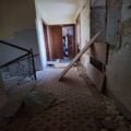 Foto zeigt notdürftig abgesperrten Fahrstuhlschacht und Schutt im Stiegenhaus des Gebäudes.
